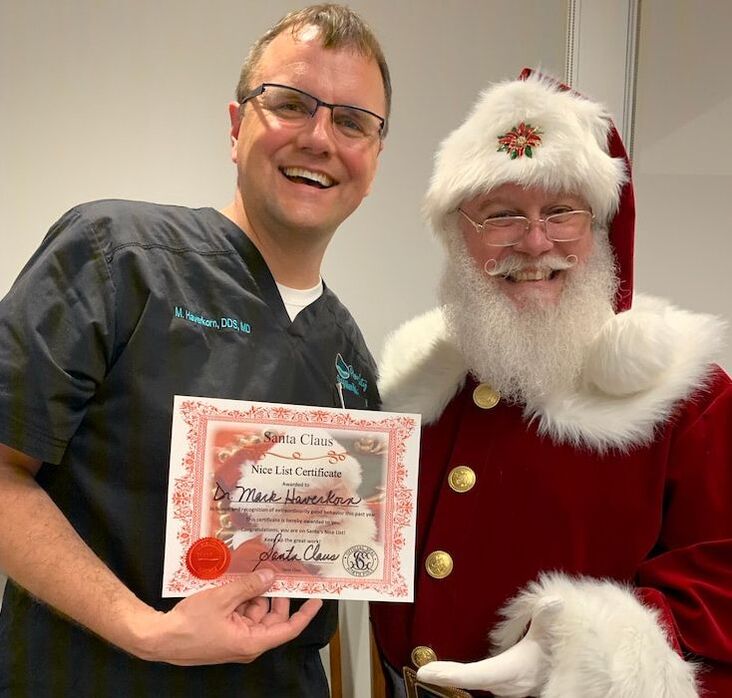 Dr. Mark Haverkorn, DDS, MD receives a Nice List Certificate from Santa Claus during Open House and one year celebration.