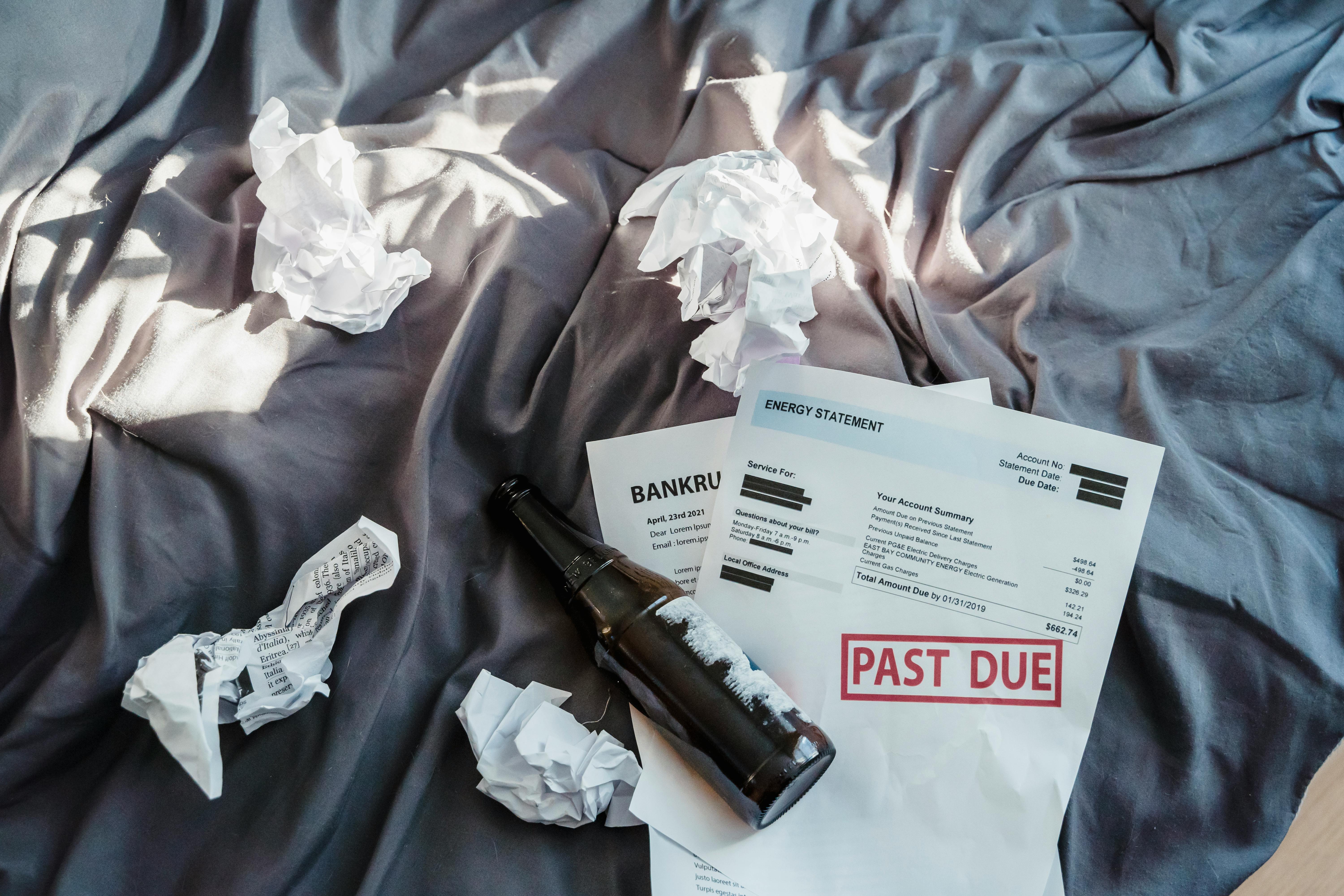 Unpaid Bills scattered on a bed for blog post Understanding ADHD Tax, Financial Costs & Tips to Avoid