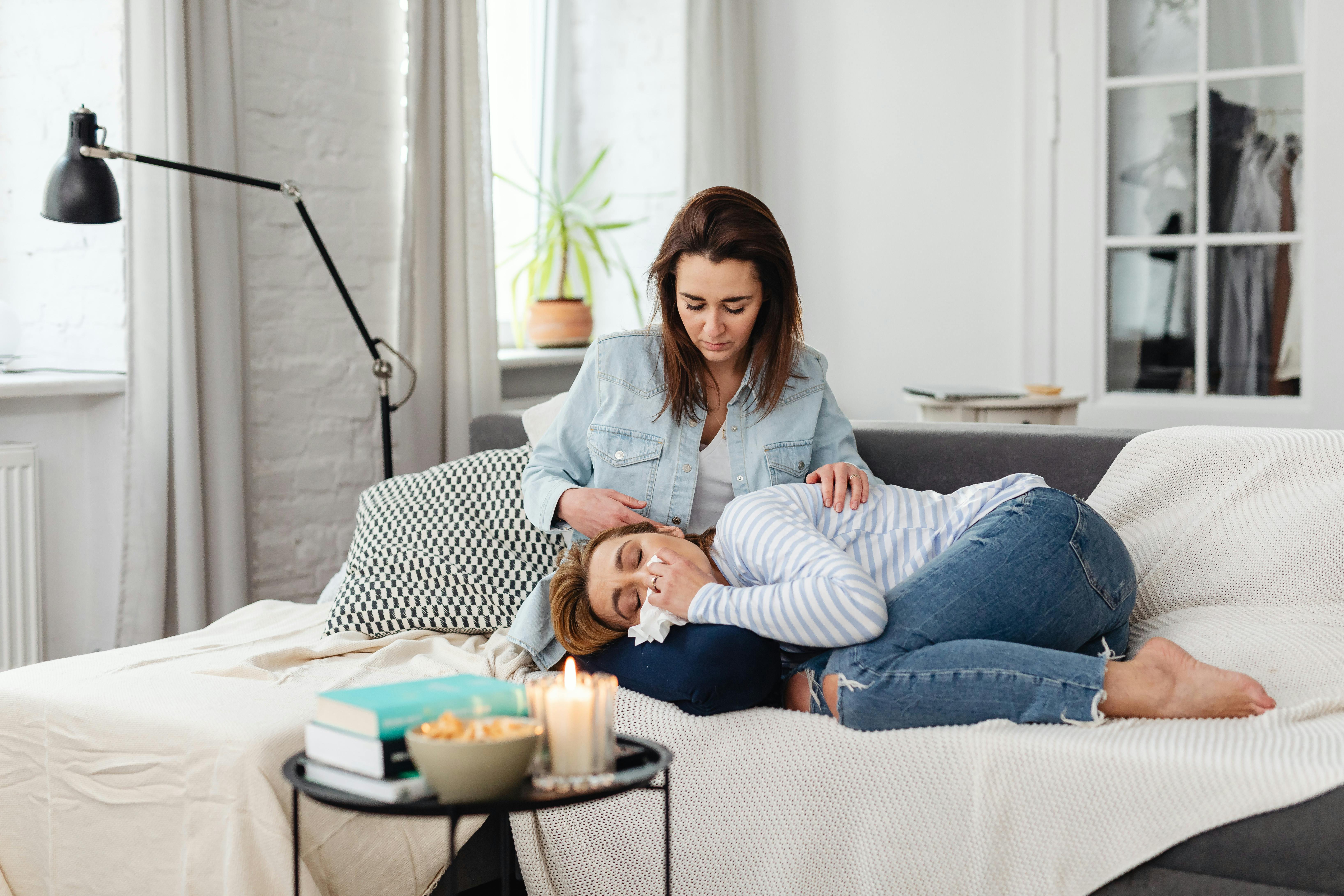 Lady crying into friends lap sat on sofa to support blog post Understanding ADHD Tax, Financial Costs & Tips to Avoid