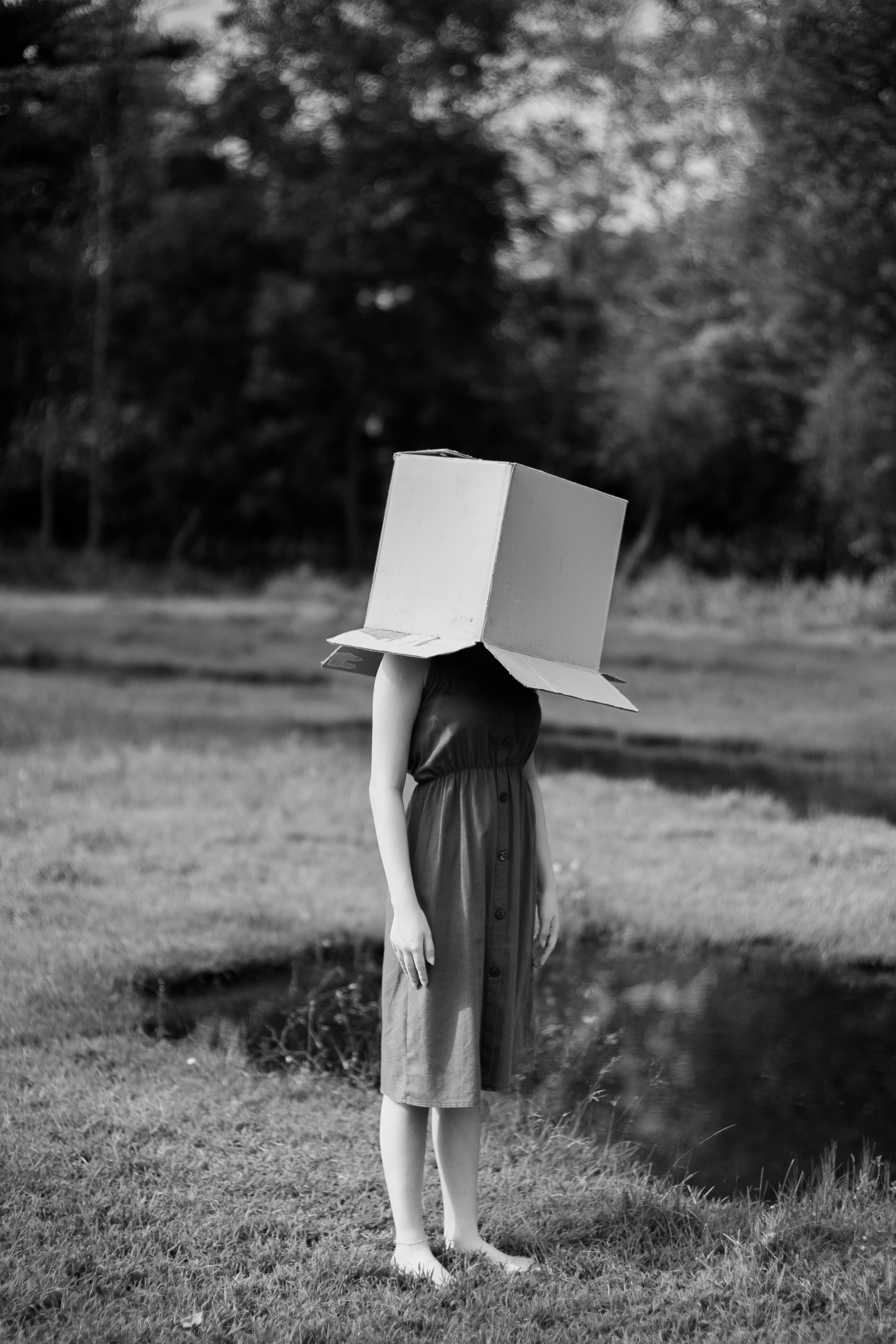 Woman stood with box on her head in a field to support blog post Is OCD Considered to be Linked to Neurodivergent People?