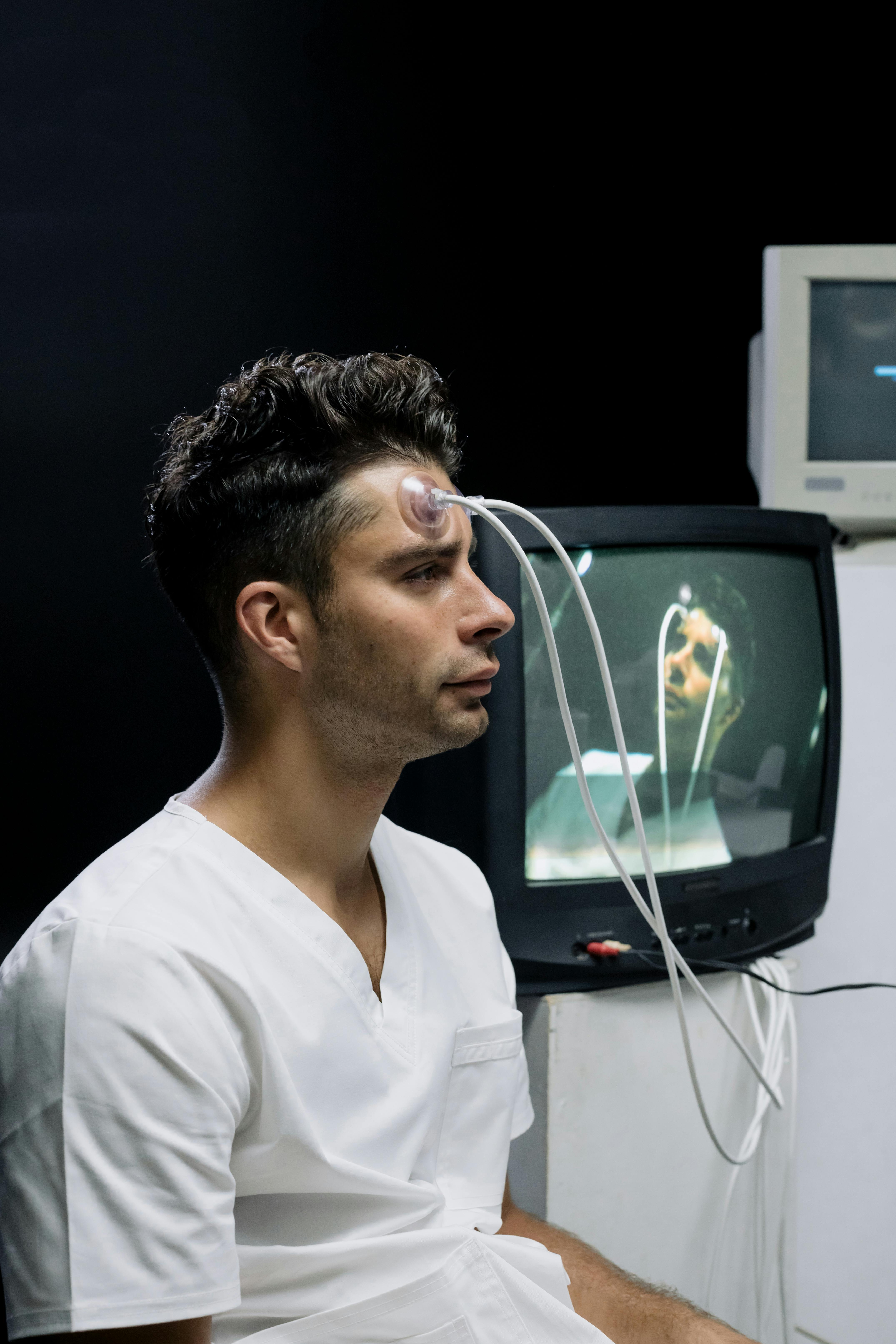 Man with wires on head sitting in dark room to support blog post Understanding ADHD, Autism and Aphantasia Connection