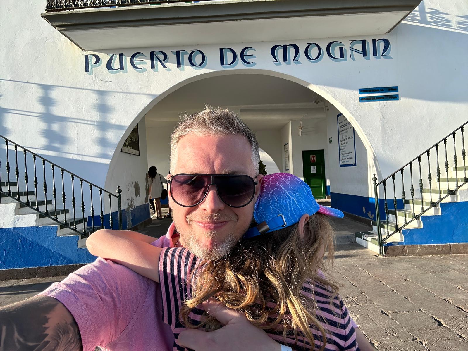 Fraser Nicoll cuddling youngest daughter in front of a port picture to support blog post What ADHD Coaching Is and How to Find a Coach