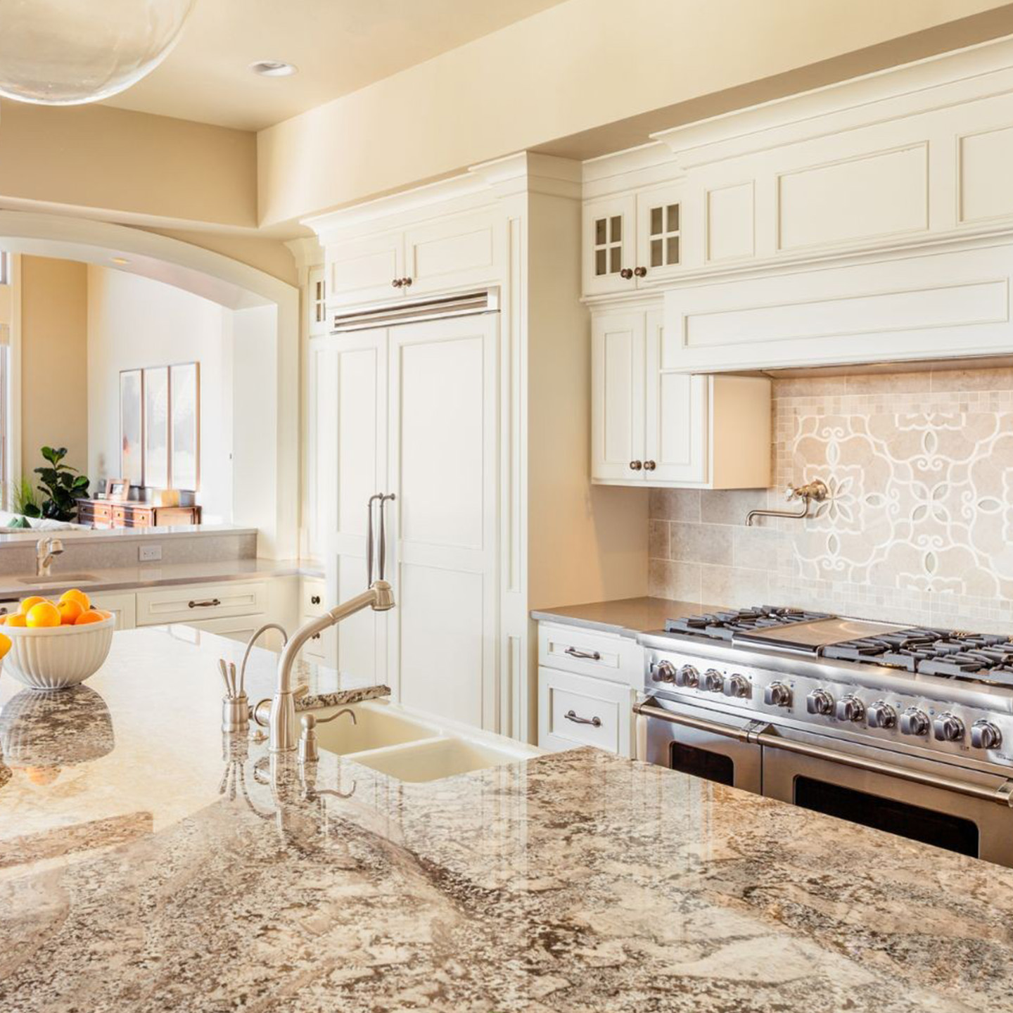 Custom kitchen remodel in Carrollton TX featuring white cabinetry, granite countertops, and modern lighting design