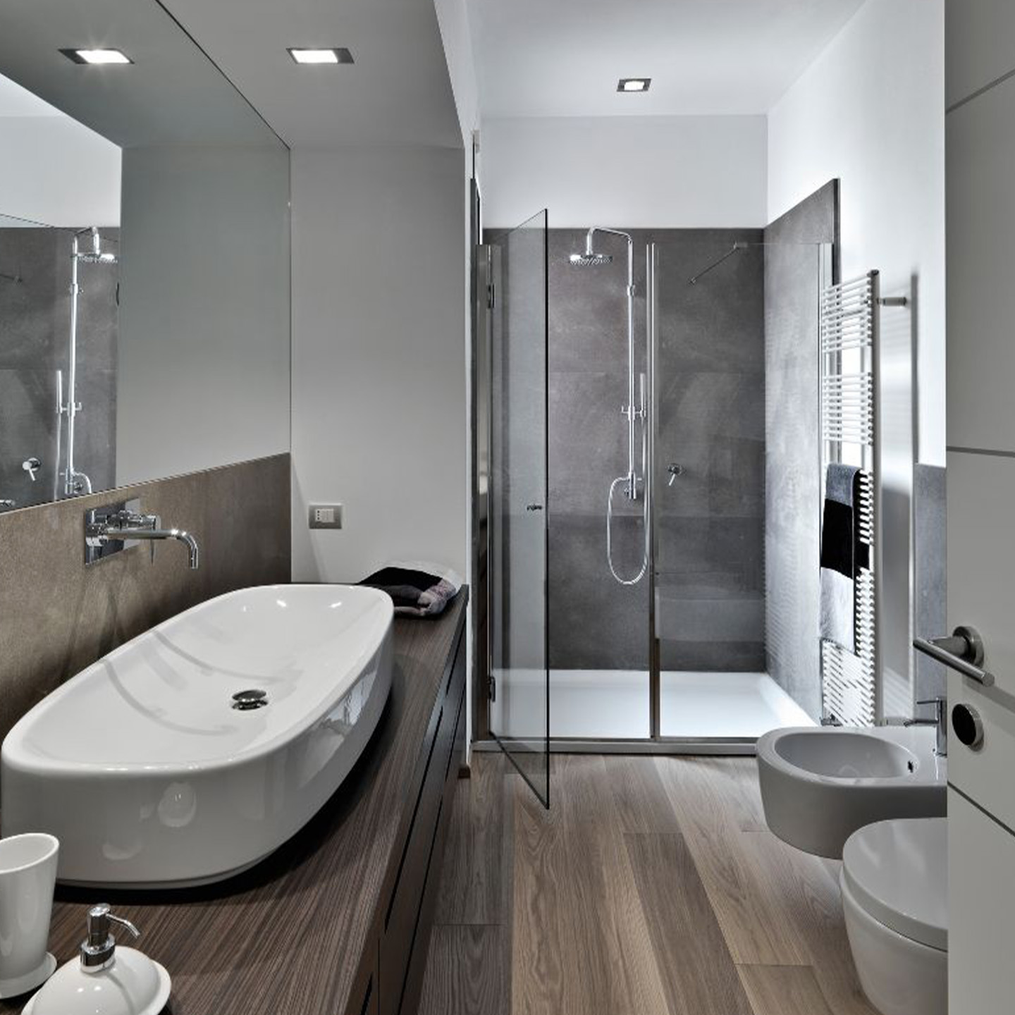 Modern bathroom remodel in Garland TX featuring a walk-in glass shower, floating vanity, and contemporary fixtures