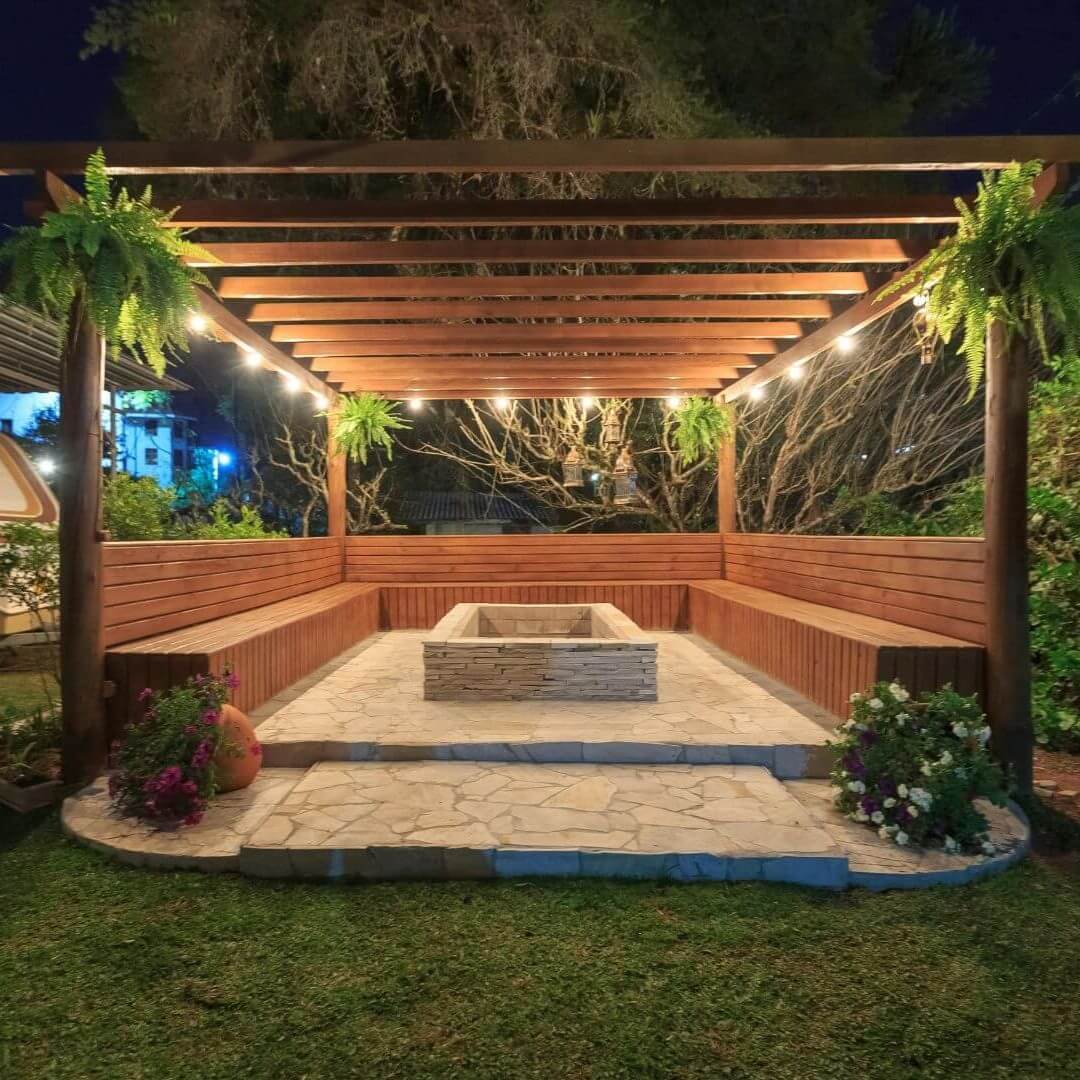 Custom pergola with built-in seating and stone firepit in Irving, TX backyard