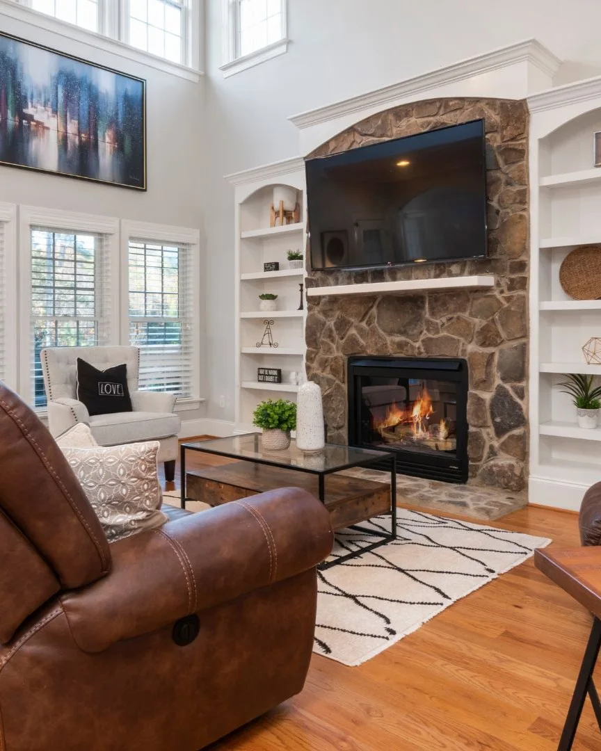 Cozy living room with stone fireplace and modern finishes, showcasing home addition remodeling in Allen, TX.