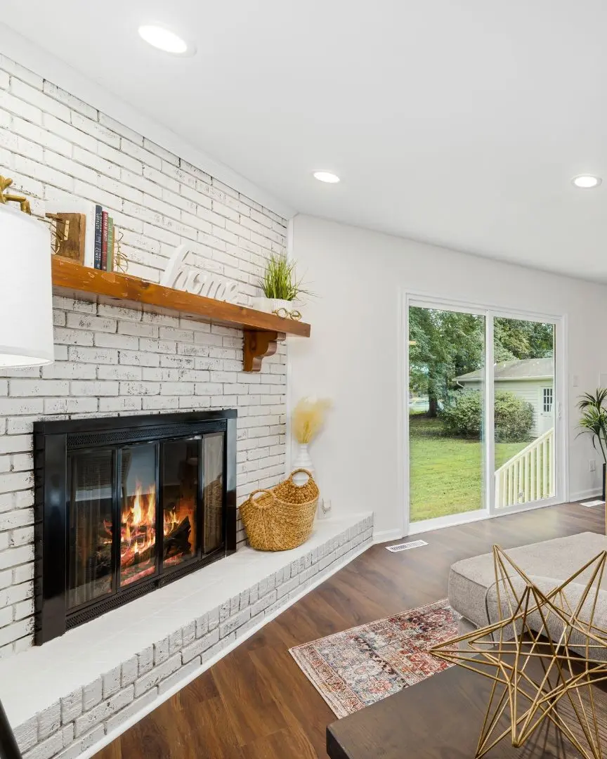 Living room home addition in Flower Mound TX with fireplace, sliding glass doors, and modern design