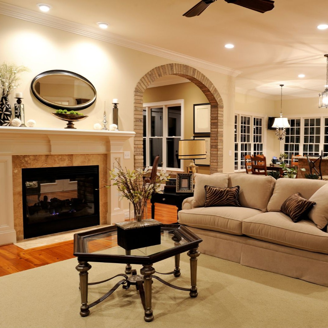 Remodeled open-concept living room and kitchen in Addison, TX featuring updated lighting, fireplace, and hardwood floors