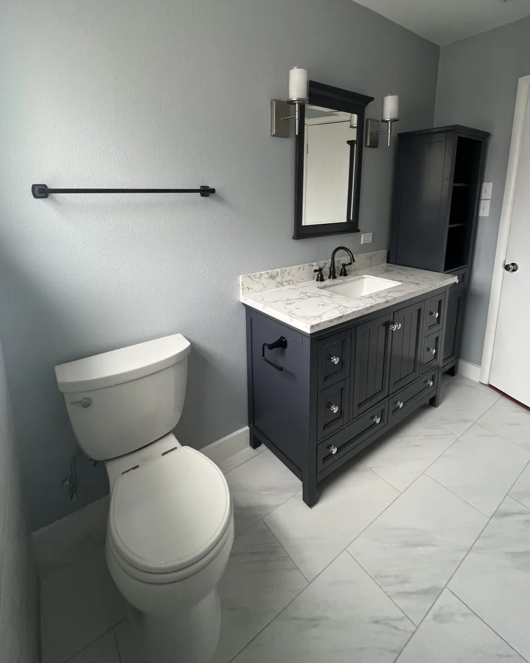 Remodeled bathroom in Addison, TX with gray vanity, marble countertop, and updated fixtures