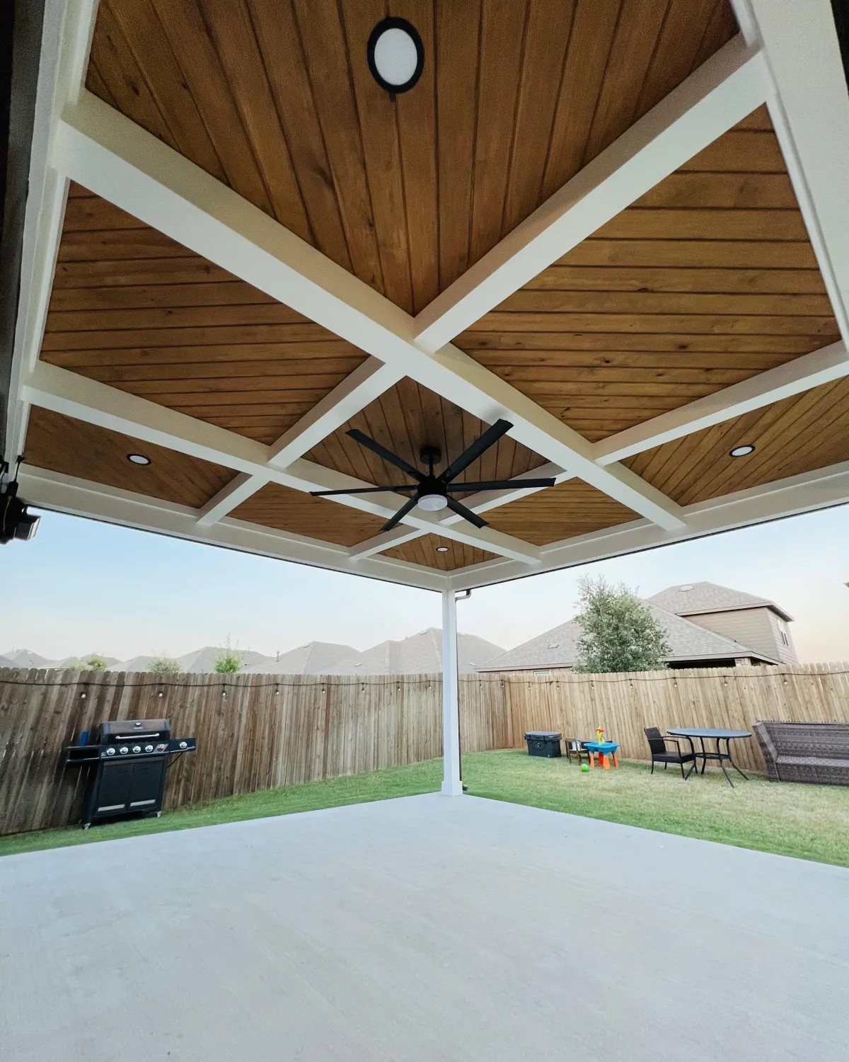 Custom covered patio in Addison, TX featuring wood ceiling panels, outdoor fan, and recessed lighting