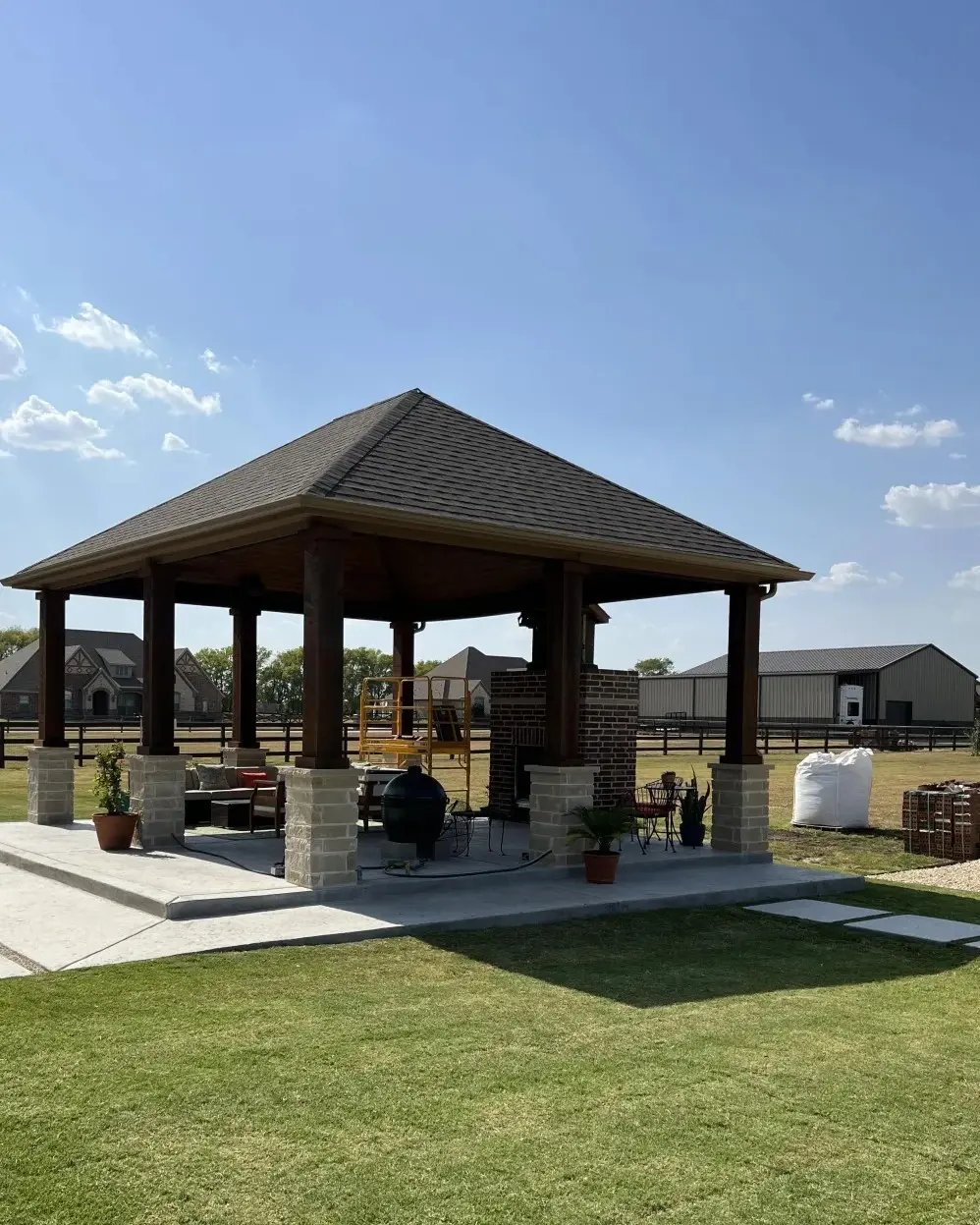 Custom-built backyard pavilion with brick columns and wood roof in Addison, TX under construction