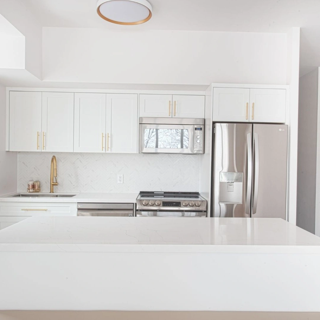 Kitchen remodel in Coppell, TX with white Shaker cabinets, quartz island, and stainless appliances