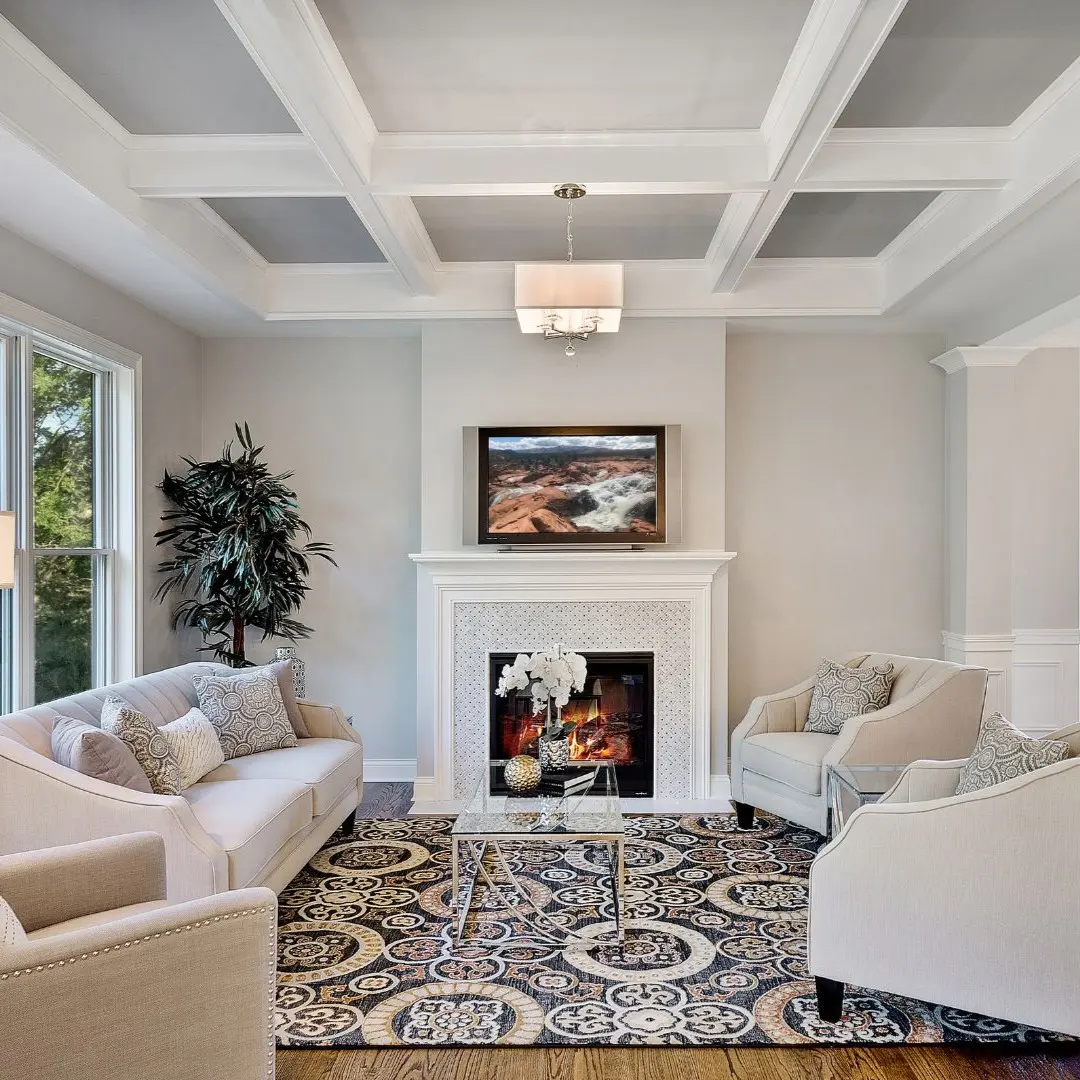 Home addition living room in Highland Village TX with coffered ceiling, fireplace, and large windows