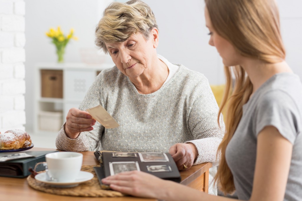 Senior woman reviewing assisted living pricing paperwork with adult daughter at the kitchen table