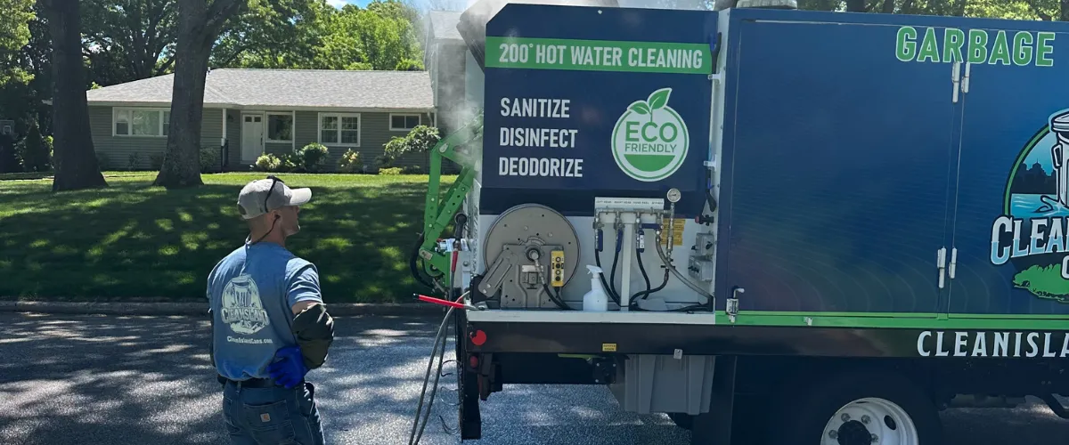 Eco-friendly trash can cleaning truck spraying bins with 200°F water in suburban area Eco-friendly trash can cleaning truck spraying bins with 200°F water in suburban area