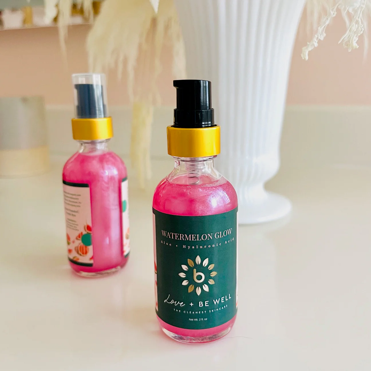 bottle of Love + Be Well's Watermelon Glow hyaluronic acid serum bottle of Love + Be Well's Watermelon Glow hyaluronic acid serum