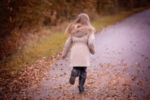 running child in fall leaves