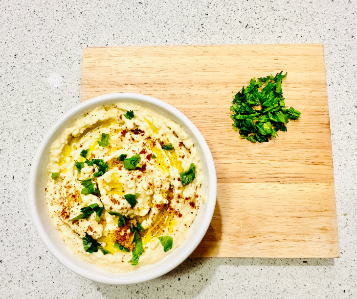 bowl with hummus, paprika, and parsley