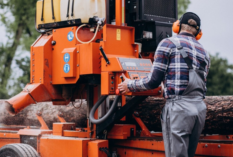 a tree professional inside a crane moving fand cutting trees a tree professional inside a crane moving fand cutting trees