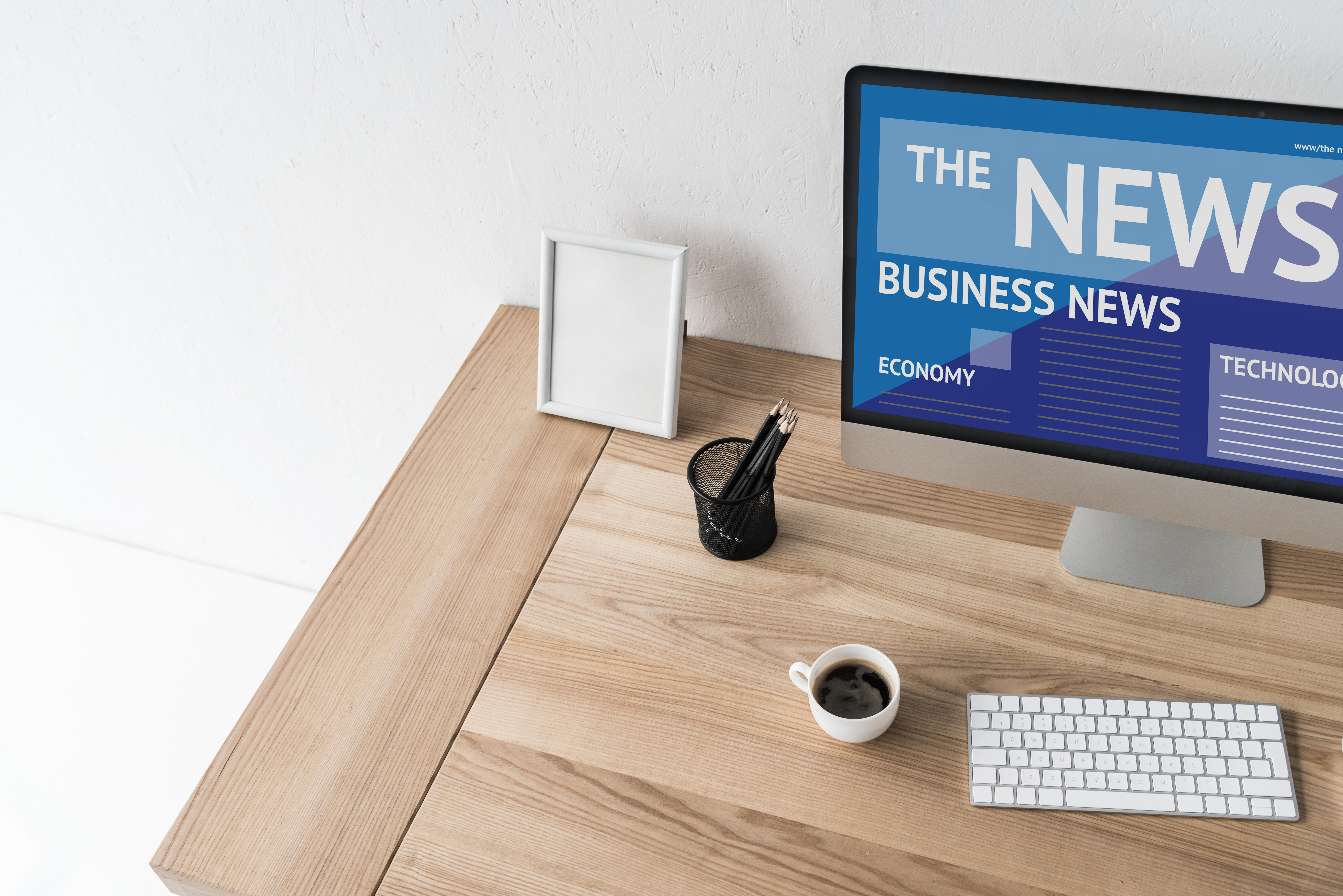 Computer monitor on desk with business news on the screen.