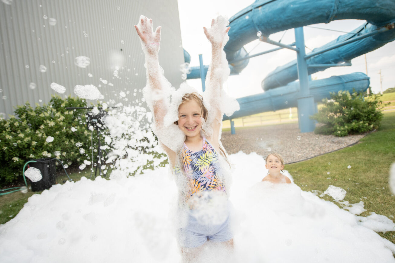 Kid playing with foam in Chaos Water Park's backyard area