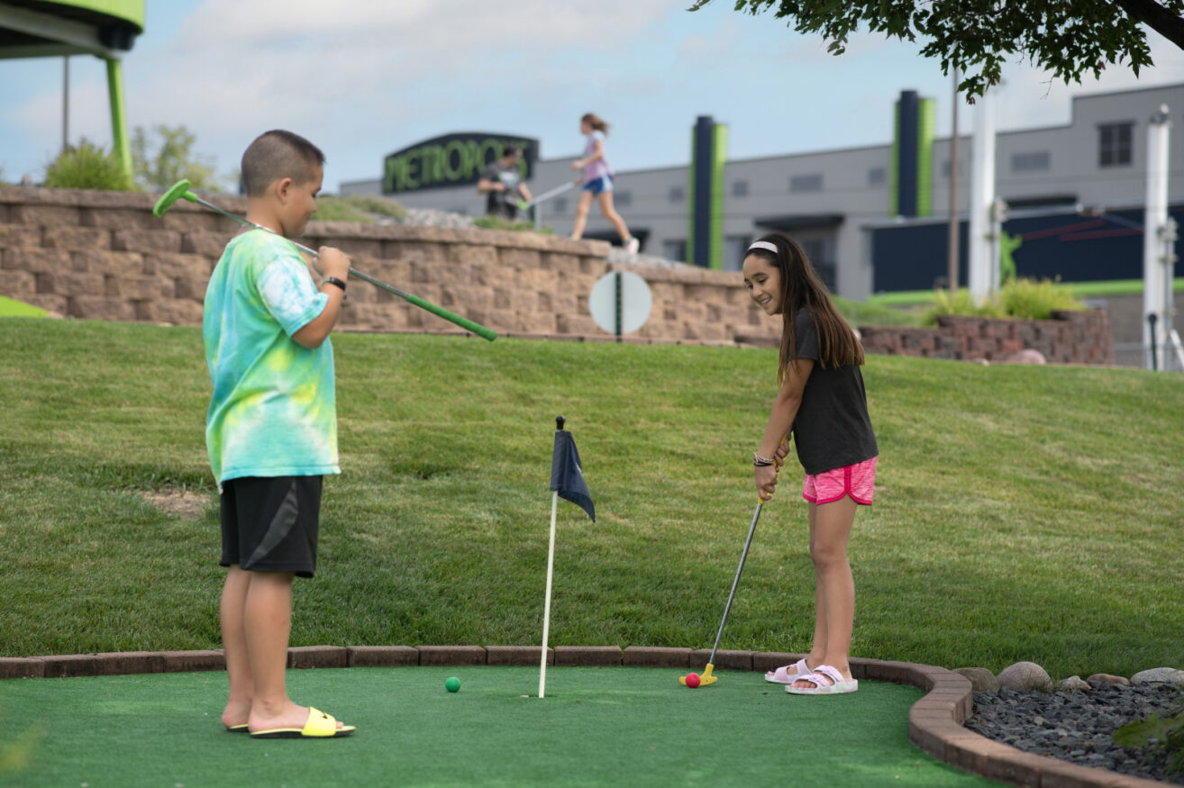 Kids playing mini golf at Action City