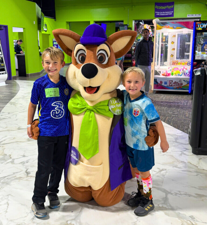 Two young brothers with Splasharoo, the Metropolis Resort mascot.