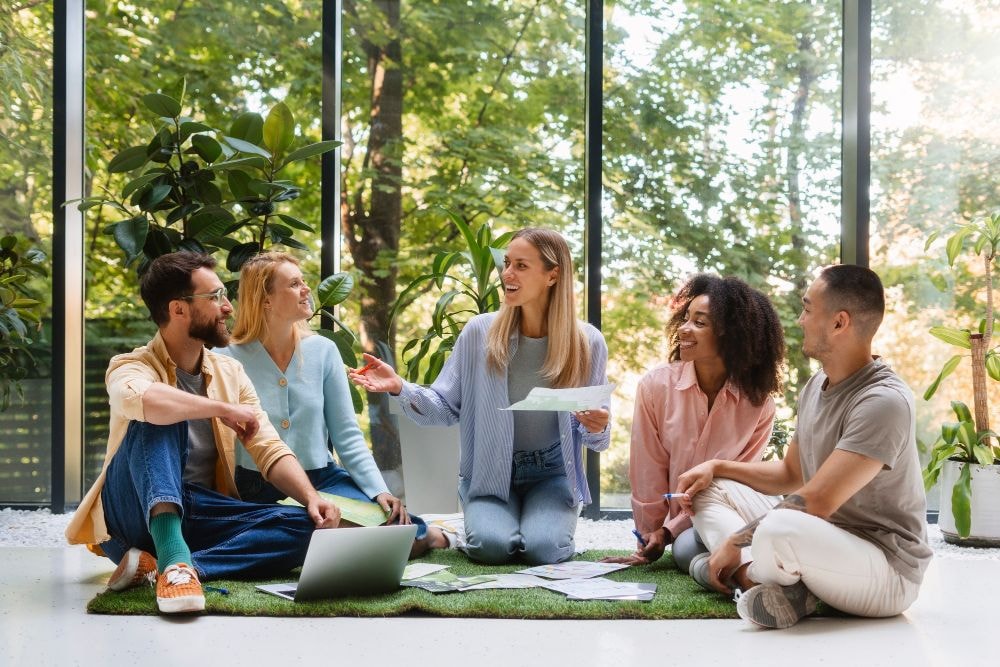Small circle of people sitting on an outside deck with a woman leading the conversation