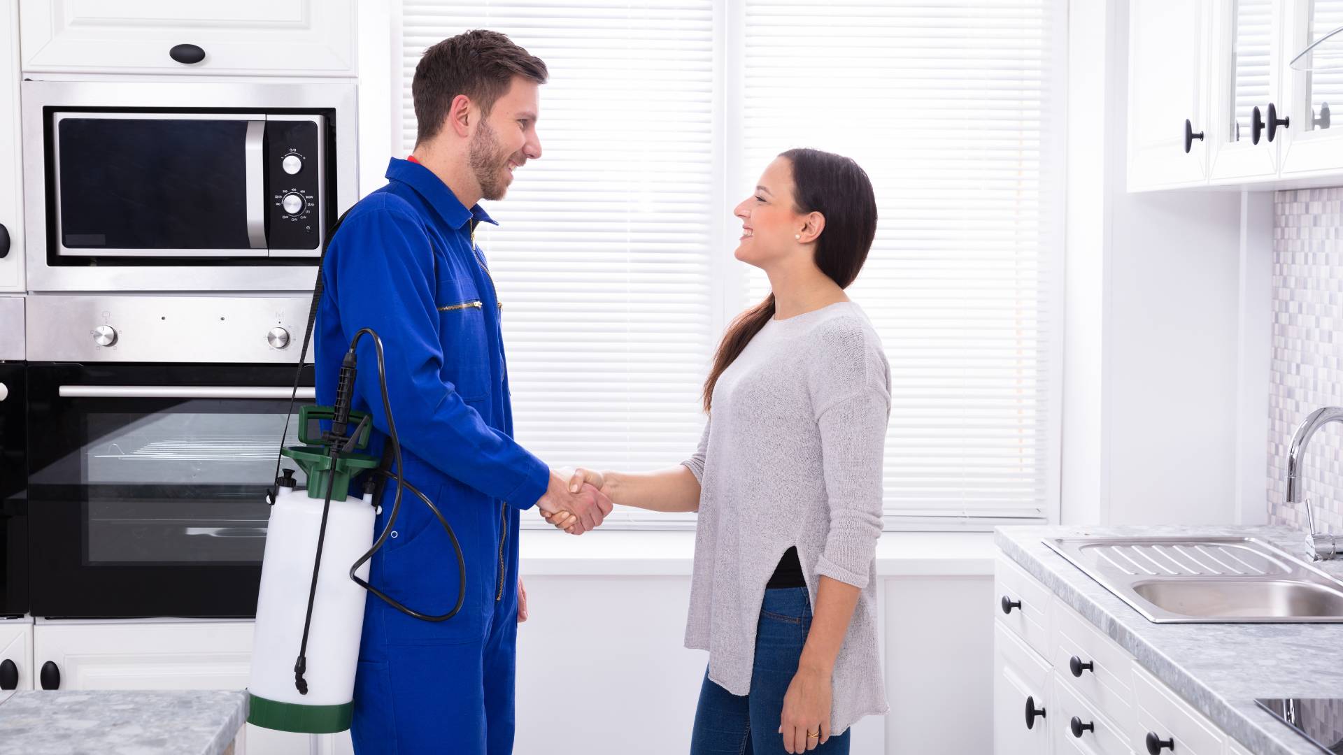 pest control professional shaking hands with a customer