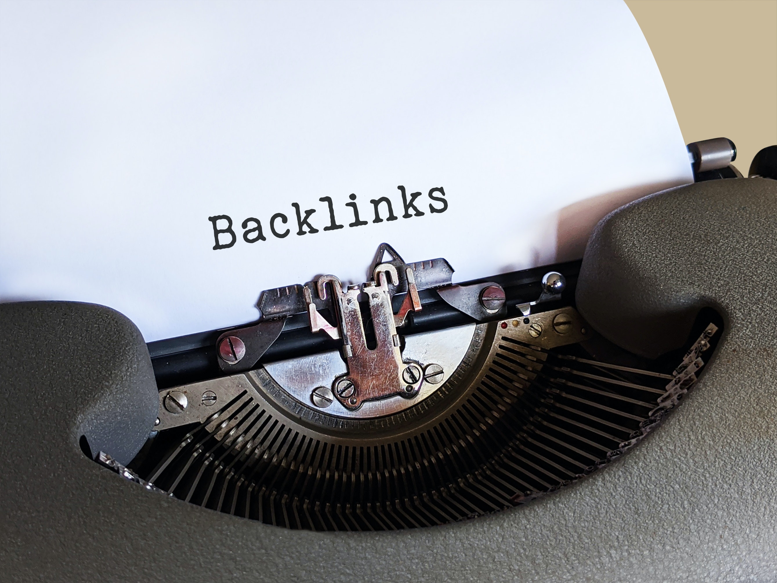 old fashioned typewriter writing the word backlinks on paper