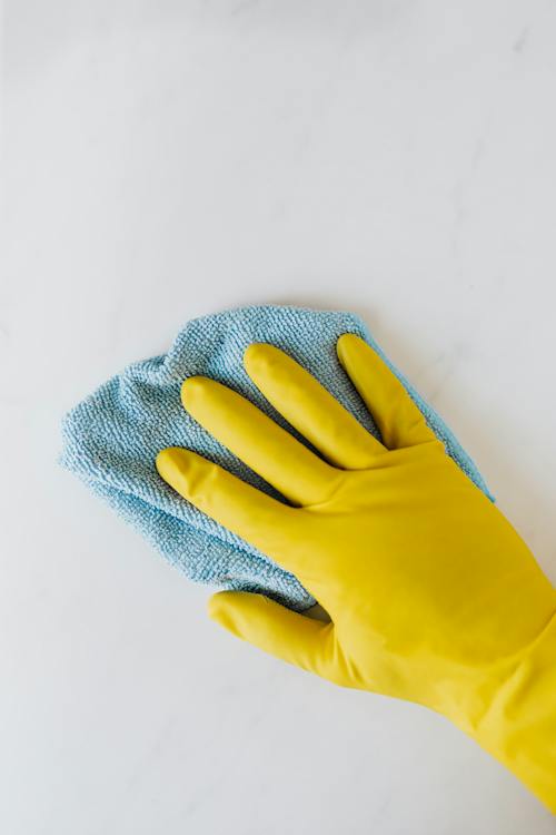 cleaning sponge in yellow gloves on hand