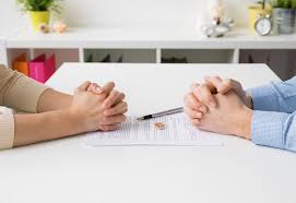 Couple Signing real estate documents with divorce papers nearby Couple Signing real estate documents with divorce papers nearby