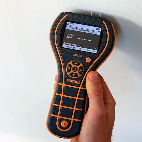 technician using moisture meter to detect mould behind wall technician using moisture meter to detect mould behind wall