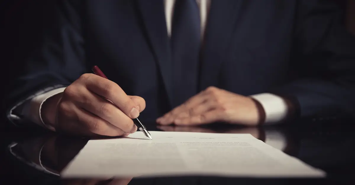 Estate planning attorney in a suit signing legal documents