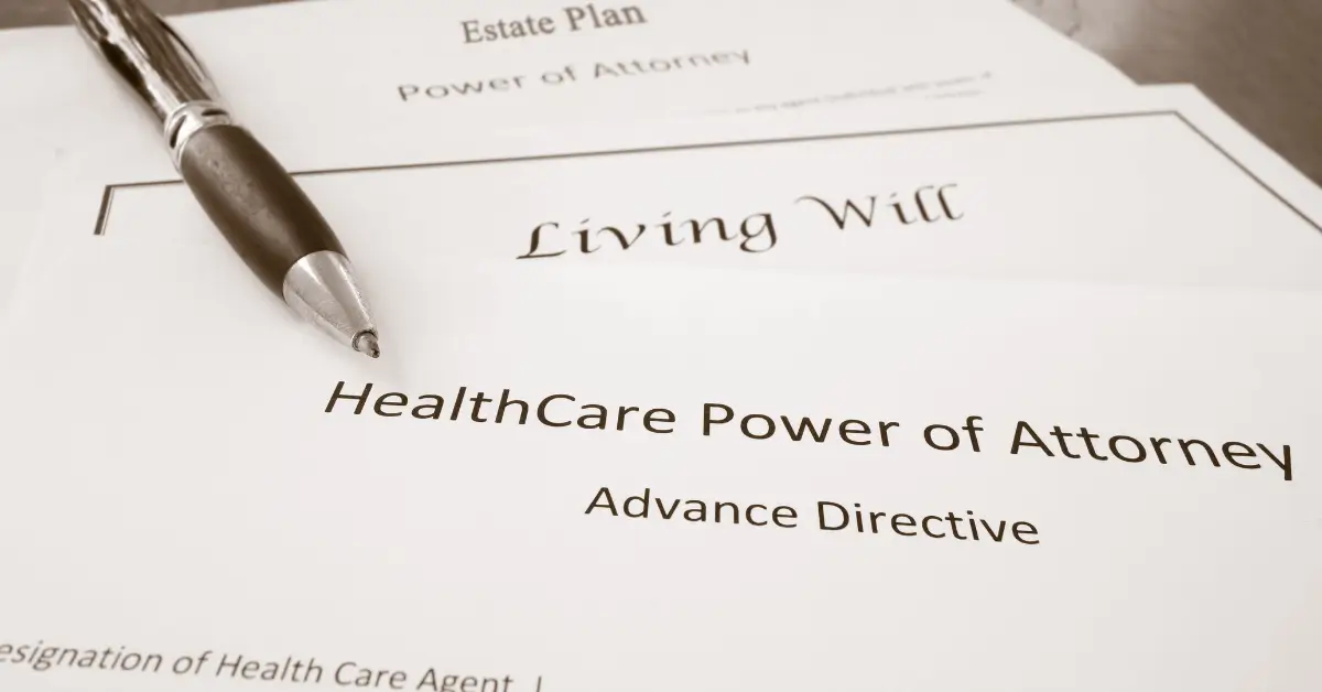 A stack of legal documents labeled “Living Will,” “HealthCare Power of Attorney – Advance Directive,” and “Estate Plan – Power of Attorney,” with a pen resting on top.