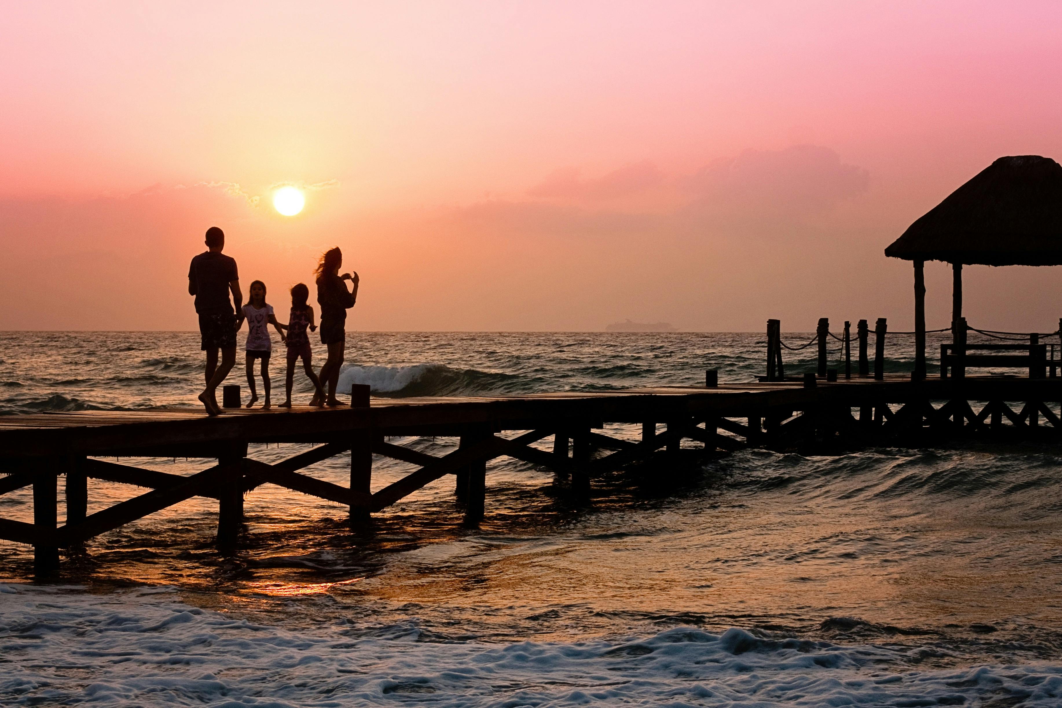 Family on dock at sunrise