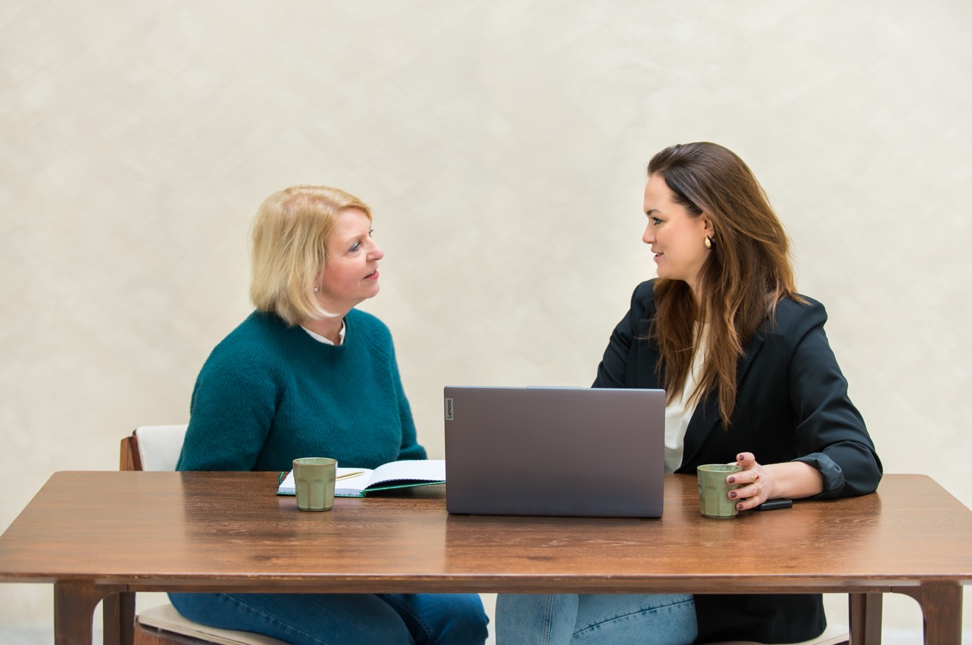 Daniëlle helpt een klant in een gesprek met het online vindbaar maken van haar website. Ze zitten aan een bureau. Daniëlle helpt een klant in een gesprek met het online vindbaar maken van haar website. Ze zitten aan een bureau.