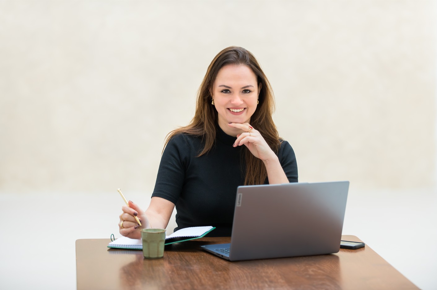Danielle zit achter haar laptop te werken met haar notitieboek naast zich. Danielle zit achter haar laptop te werken met haar notitieboek naast zich.
