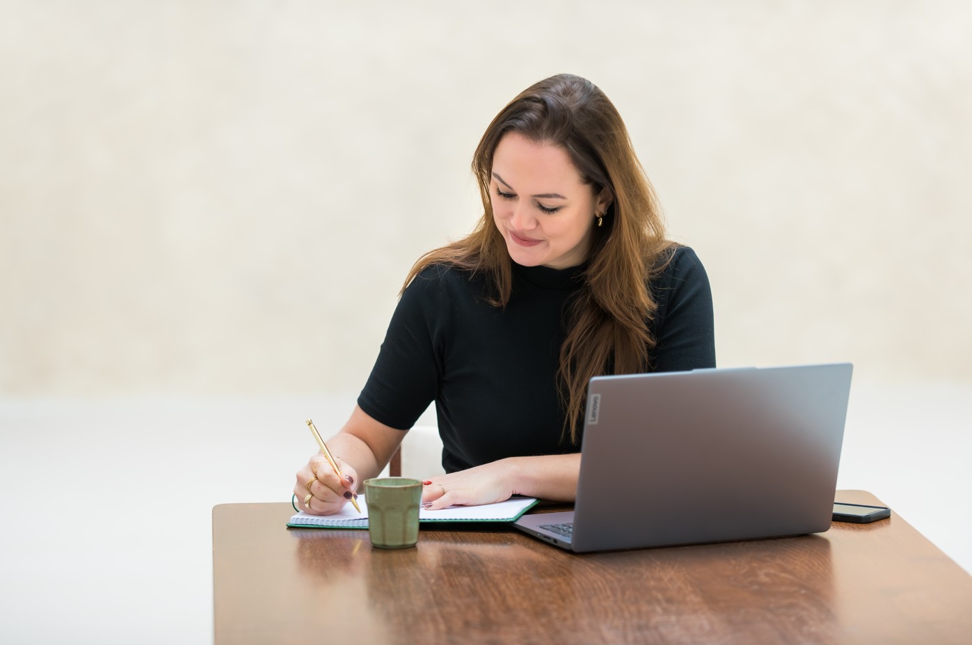 Daniëlle Bom schrijft in een notitieboek dat naast haar laptop ligt. Daniëlle Bom schrijft in een notitieboek dat naast haar laptop ligt.