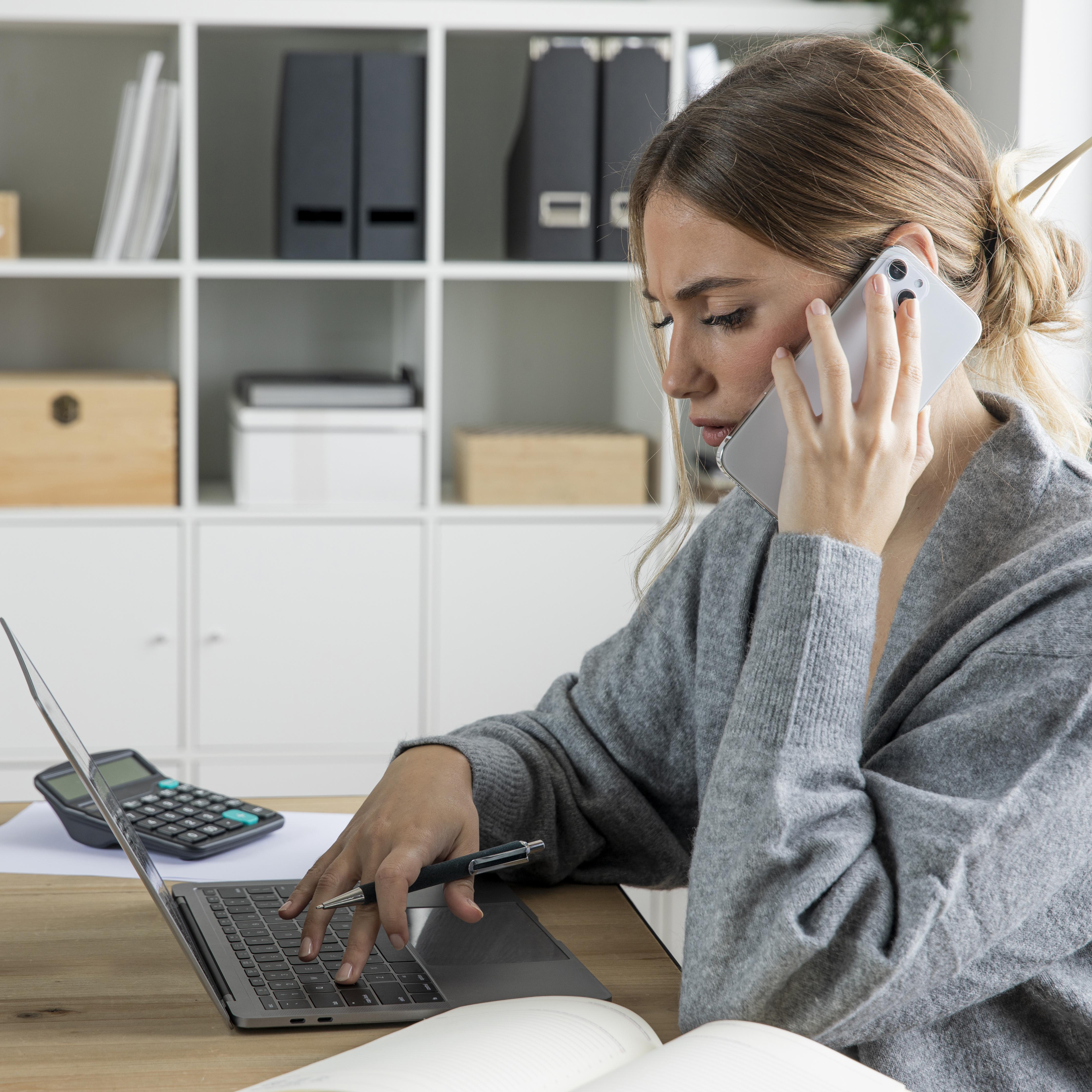 Professional making a Pay Per Call inquiry while working on her laptop in a home office