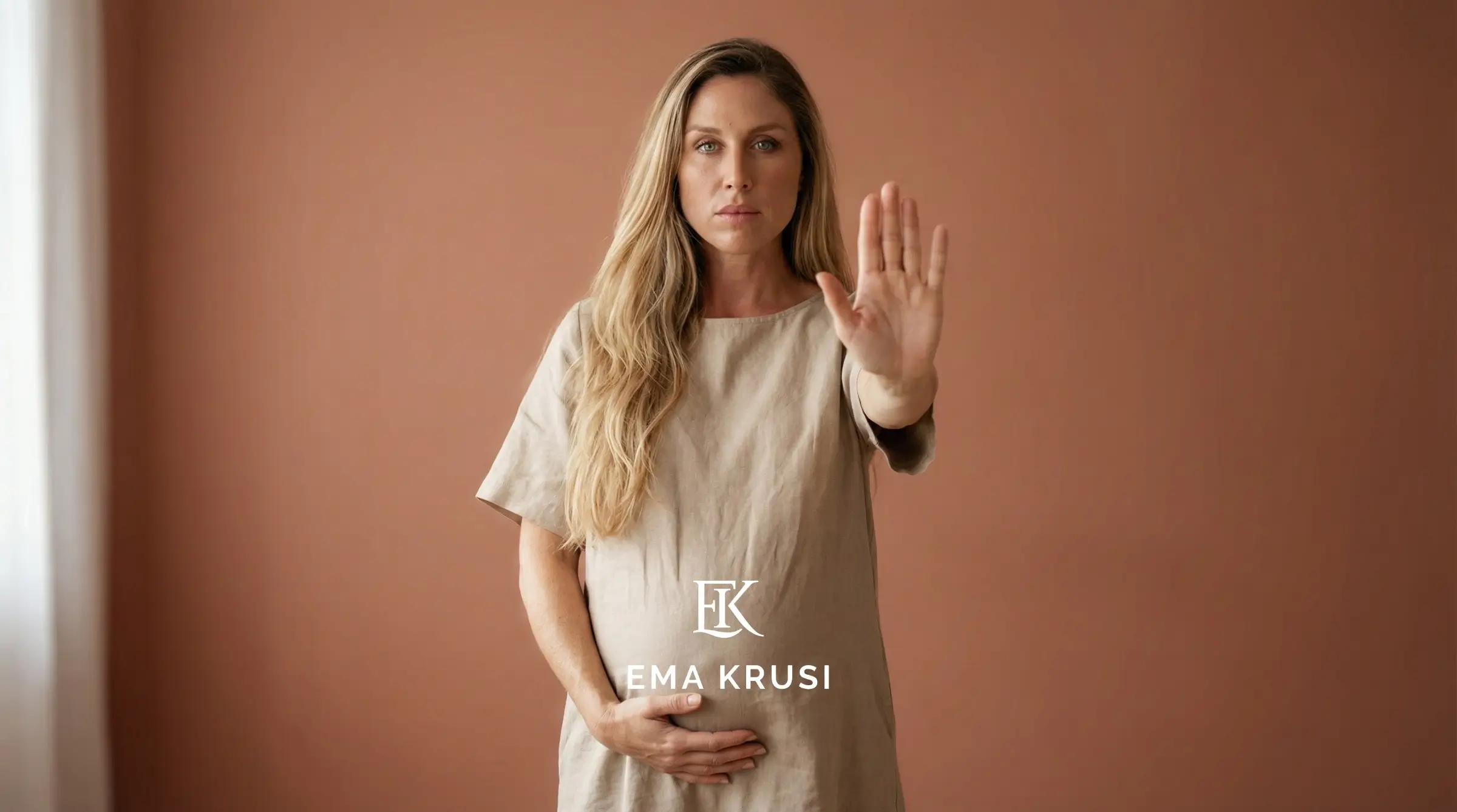 Femme enceinte debout une main sur son ventre et une en avant comme pour dire stop