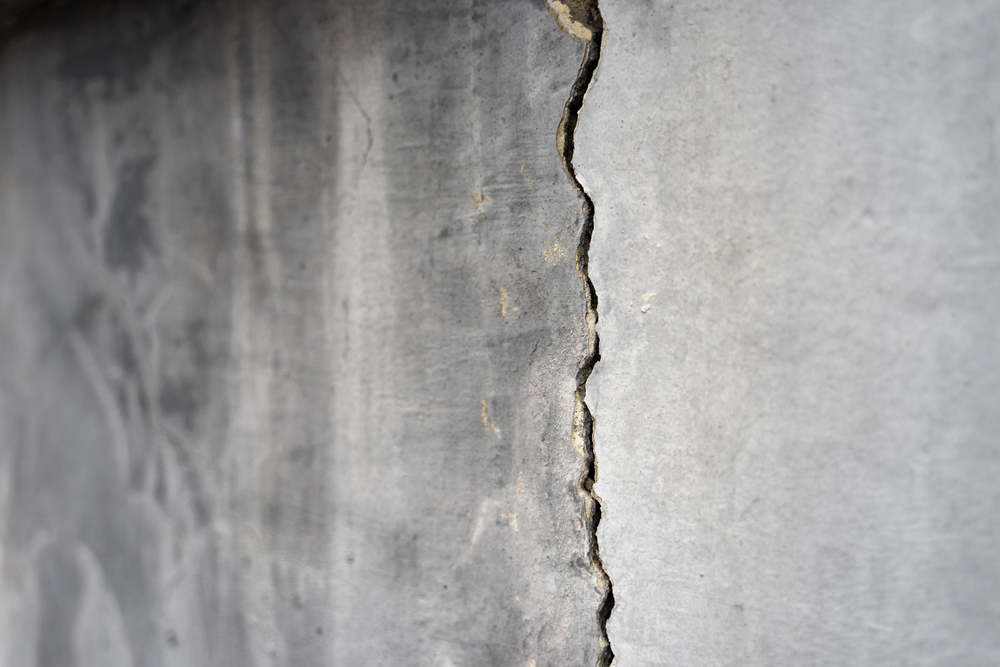 A close-up of a vertical crack running down a concrete wall