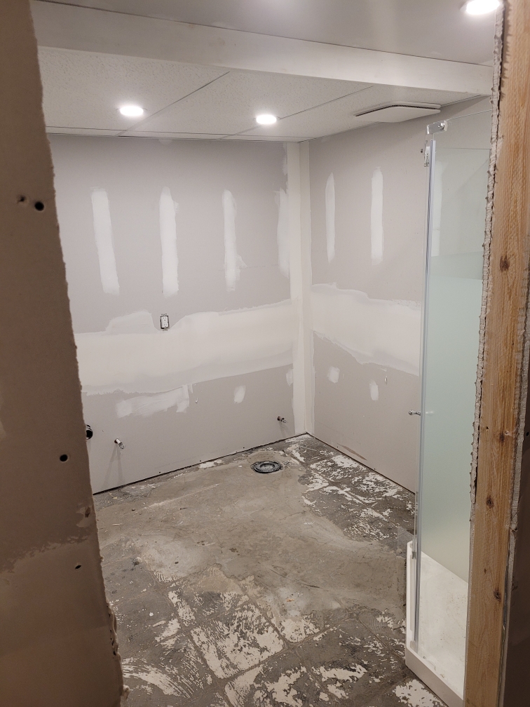 Smooth drywall finish and fresh paint in a serene bathroom color palette.