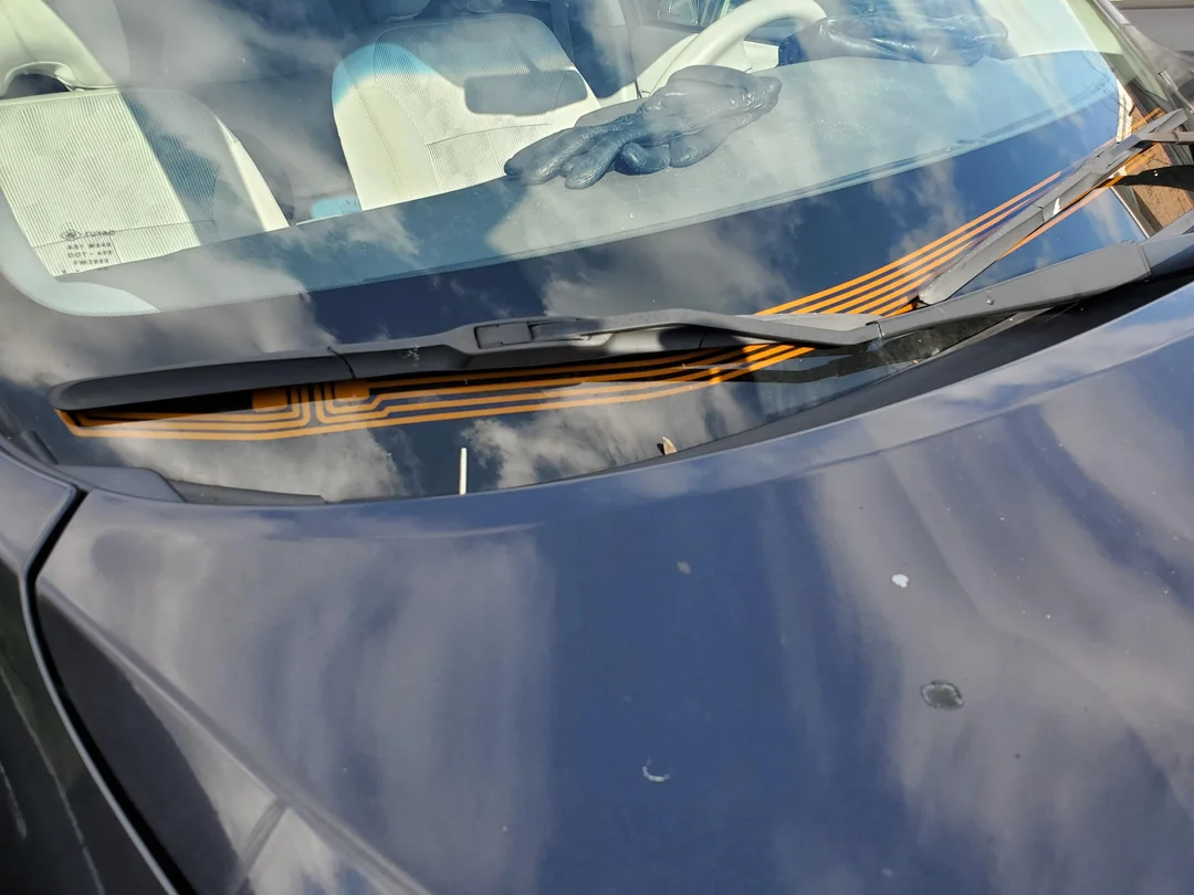 Heated wiper park system melting ice on a vehicle windshield Heated wiper park system melting ice on a vehicle windshield