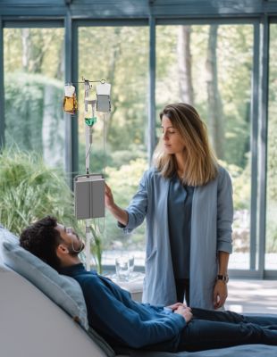 Patient receiving IV drip for adrenal fatigue recovery under medical supervision at One8 Clinic wellness facility