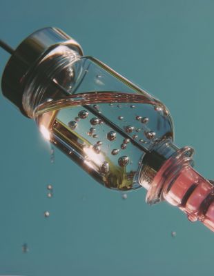 Close-up of an iron IV drip vial and syringe highlighting intravenous iron infusion for treating fatigue and iron deficiency.