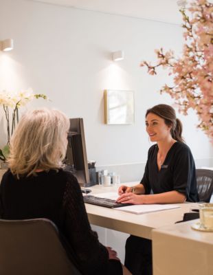 Friendly consultation at One8Clinic in Melrose Arch, Sandton, where a professional aesthetic injector discusses personalised dermal filler treatment plans for natural facial rejuvenation.