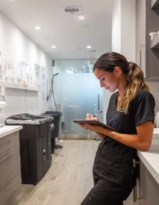 “Qualified medical professional preparing patient notes before a microneedling session at One8Clinic in Melrose Arch, ensuring safe, precise treatment for acne and surgical scar rejuvenation.”