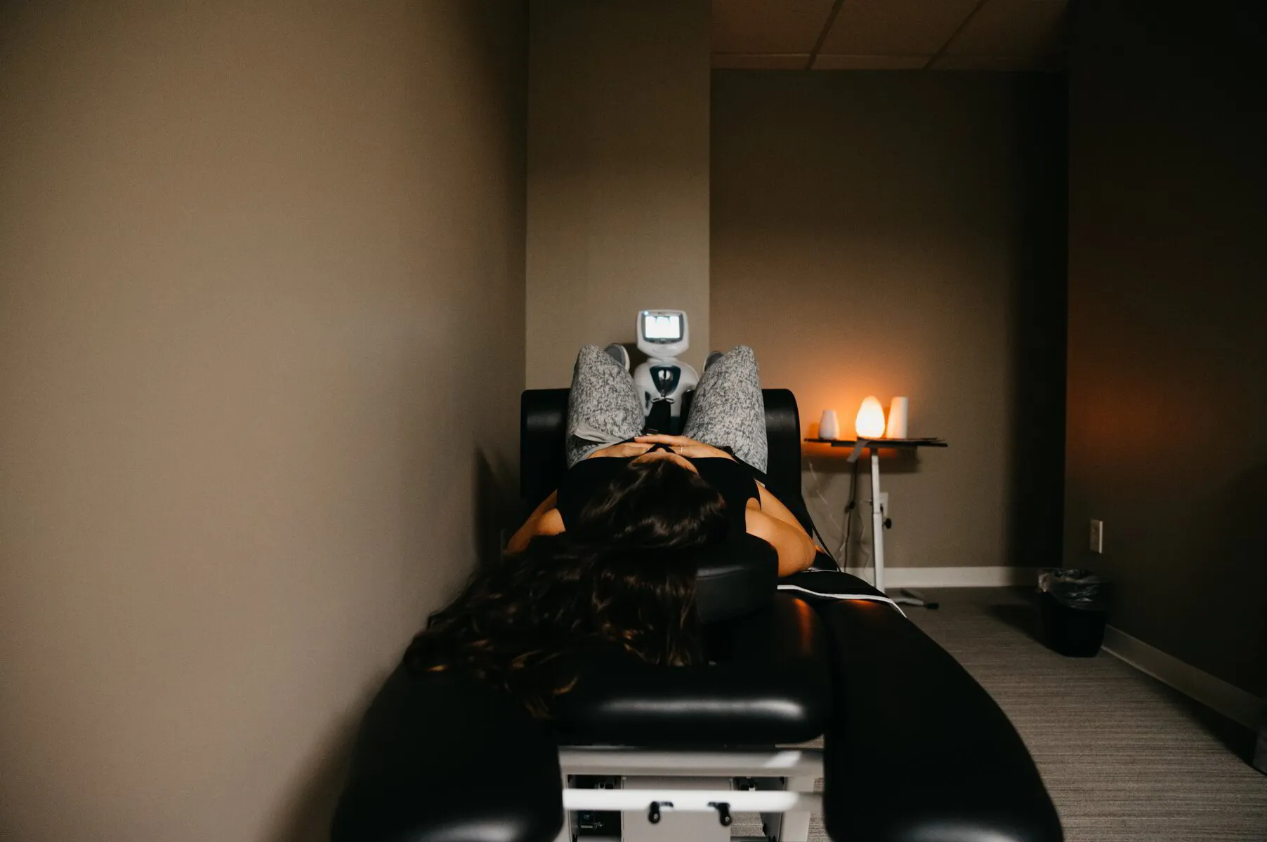 A calming chiropractic treatment room with a spinal decompression table and soft lighting to reflect a comfortable, safe environment