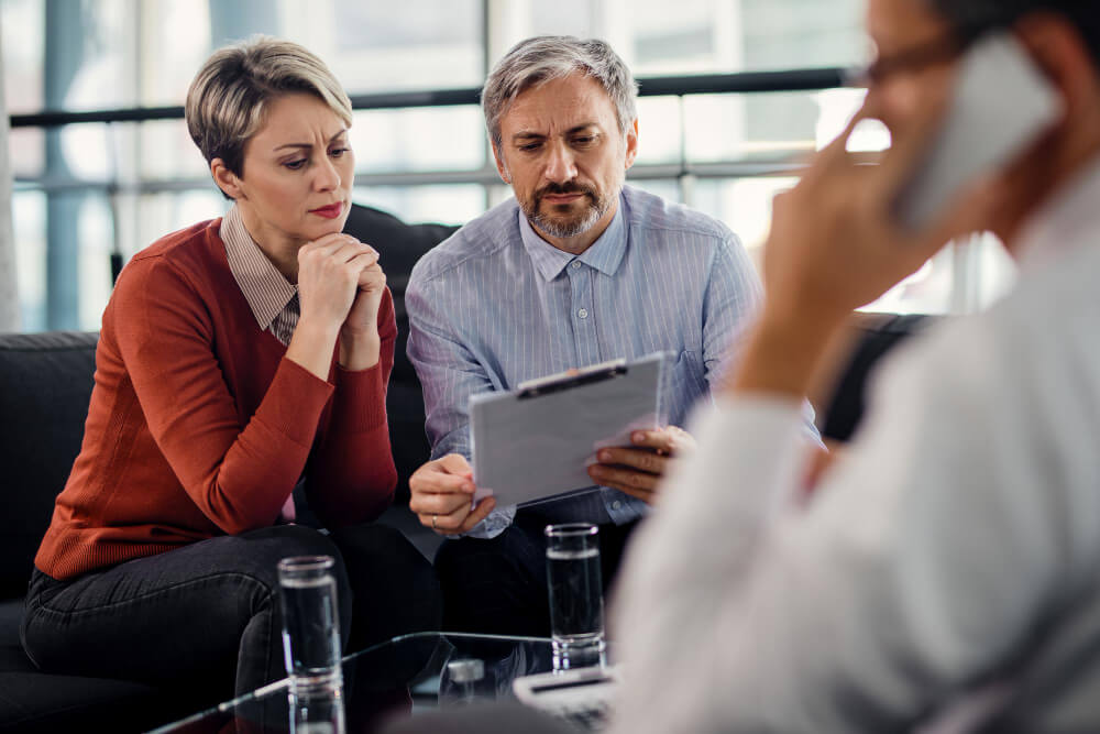 suspicious-couple-going-through-insurance-agreement-while-being-meeting-with-their-agent